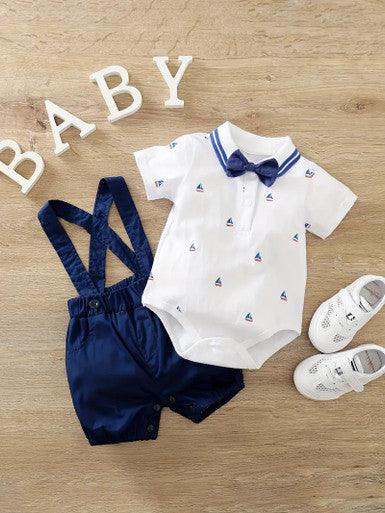 A 2-piece infant boys' outfit featuring a sailboat-themed short-sleeve shirt with a bowtie, snap bottom, and navy blue suspender shorts, perfect for a charming and stylish look.