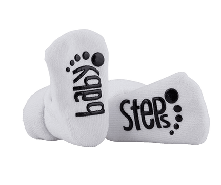 Pair of white baby socks with the words "baby steps" printed in black, each word accompanied by a small footprint design. The socks are soft and comfortable, perfect for a baby's early milestones.