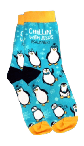 Colorful socks featuring a playful penguin pattern on a bright blue background. The socks have yellow cuffs, heels, and toes, with the text "Chillin' with Jesus Psalm 16:8" printed near the top. The design combines a fun winter theme with an inspirational message.