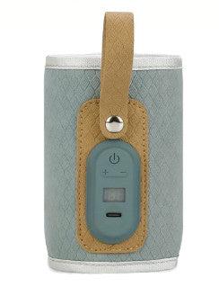 A compact, portable Bluetooth speaker with a textured light blue and tan design. The speaker features a control panel on the front with power and volume buttons, as well as a small digital display. It has a tan leather-like strap attached to the top, making it easy to carry or hang. The overall design is stylish and functional, ideal for on-the-go music or audio listening.