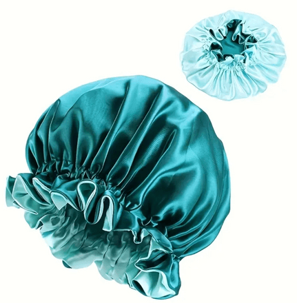 A reversible satin bonnet with one side in a vibrant teal and the other in a lighter, pastel aqua shade. The bonnet features a stylish ruffled edge and is made from smooth satin material, designed to protect hair from breakage and frizz. The reversible design provides the option to switch between the bold teal and the softer aqua, making it both functional and versatile.