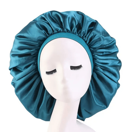 A shiny teal satin bonnet displayed on a mannequin head with closed eyes. The bonnet features a smooth, luxurious texture, designed to protect hair while sleeping. It has an elastic teal band around the edge, ensuring a secure and comfortable fit. The satin material is ideal for reducing friction, retaining moisture, and minimizing hair breakage, making it perfect for maintaining healthy hair. This bonnet is both functional and stylish, suitable for all hair types, with a bold, eye-catching color.