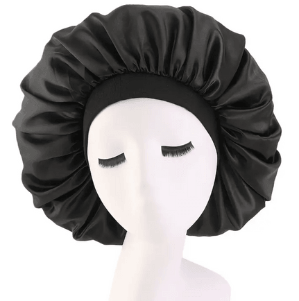 A sleek black satin bonnet displayed on a mannequin head with closed eyes. The bonnet has a smooth, glossy finish, providing a protective layer for hair, particularly useful for reducing friction and preventing hair damage while sleeping. It features an elastic band around the edge, ensuring a secure and comfortable fit. The satin material is gentle on hair, helping to retain moisture and minimize breakage. The bonnet is designed for all hair types, offering both style and functionality in hair care.